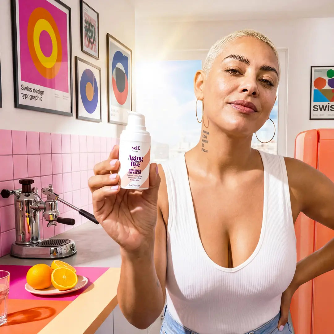 Woman holding Yelf Aging Bye Bye Hyaluron Eye Cream in a bright modern kitchen with fresh ingredients and natural morning light.