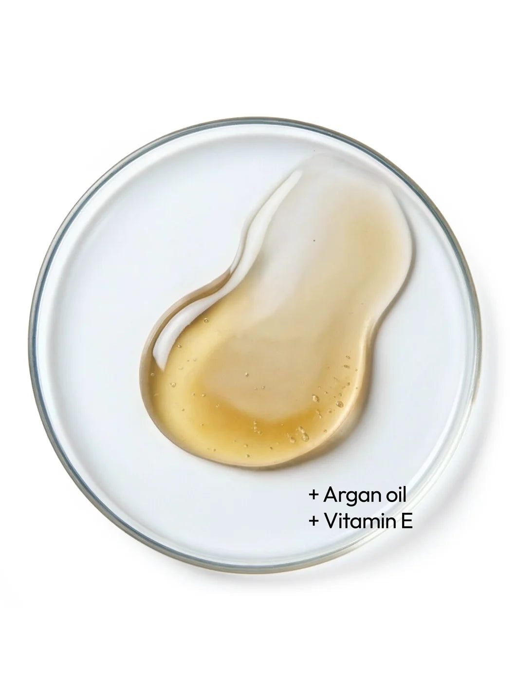 Top view of a golden liquid with fine bubbles in a petri dish, illustrating argan oil and vitamin E as key antioxidant ingredients used in Yelf Nourishing Day Cream