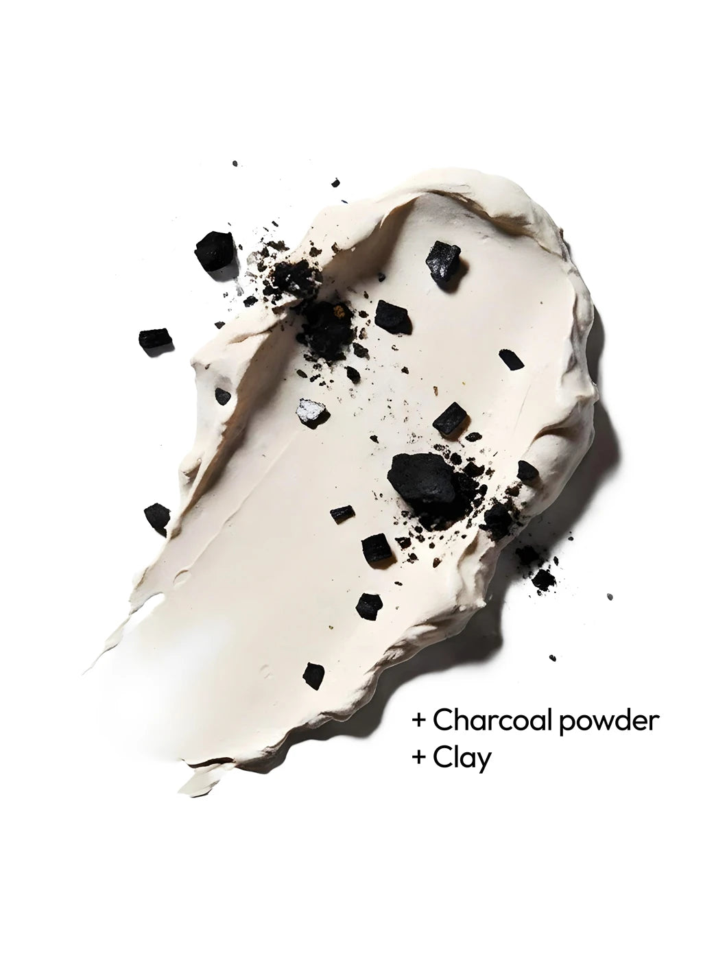 Top view of charcoal powder and clay on a creamy texture, illustrating purifying ingredients used in Yelf Spot Off Acne Cream