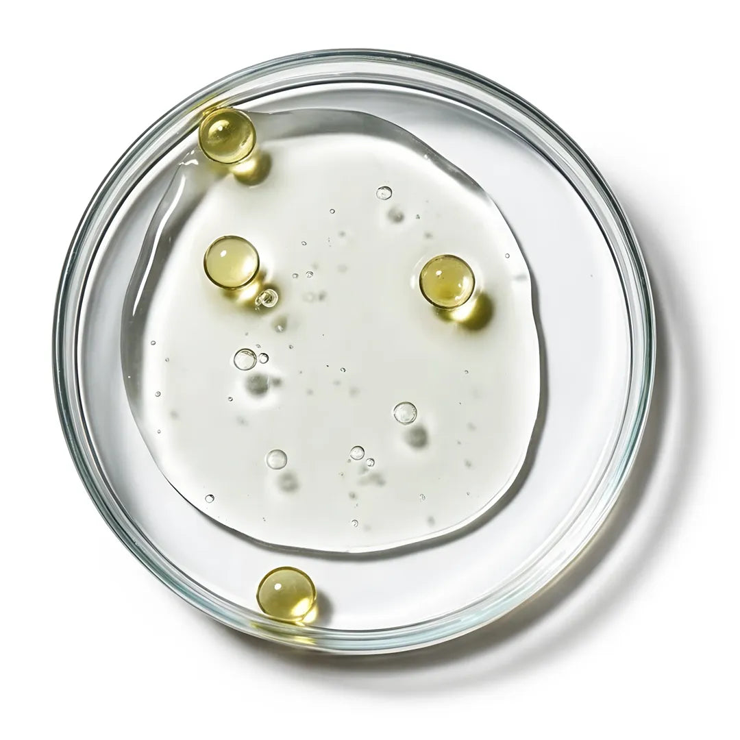 Top view of a transparent gel with oil droplets in a petri dish representing Yelf Spot Off Acne Cream with salicylic acid and tea tree oil.
